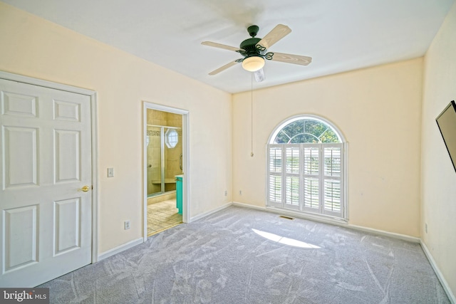 spare room featuring light colored carpet and ceiling fan