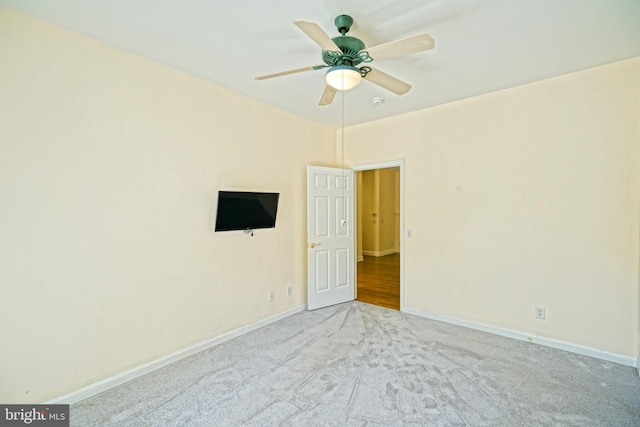 empty room featuring ceiling fan and light carpet