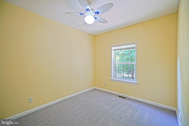 carpeted spare room featuring ceiling fan