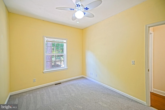 carpeted spare room featuring ceiling fan