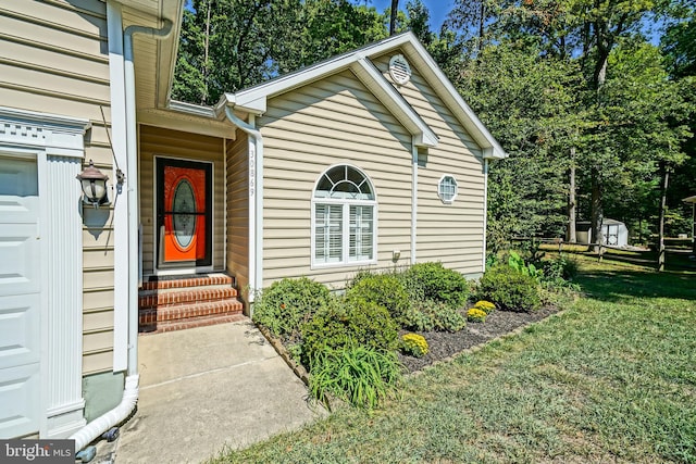 view of exterior entry with a yard