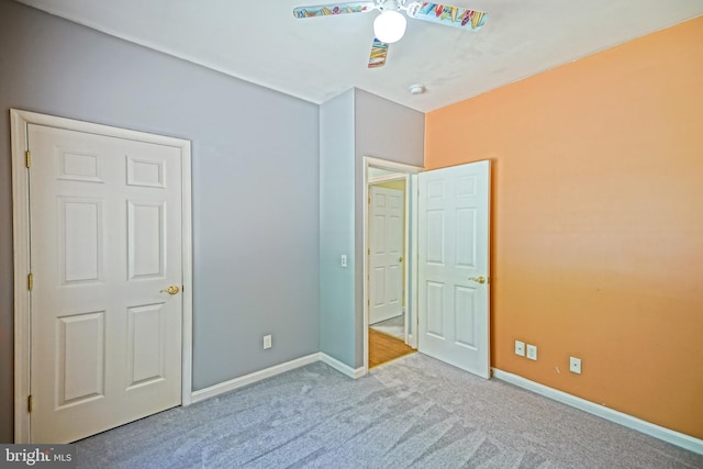 unfurnished bedroom featuring light carpet and ceiling fan