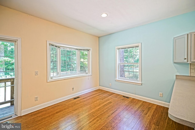 unfurnished dining area with a wealth of natural light and wood-type flooring