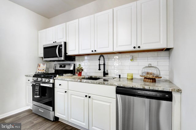 kitchen featuring stainless steel appliances, dark hardwood / wood-style floors, sink, and white cabinetry