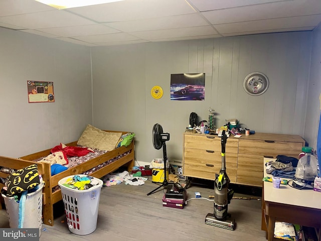 bedroom with a paneled ceiling and wood-type flooring