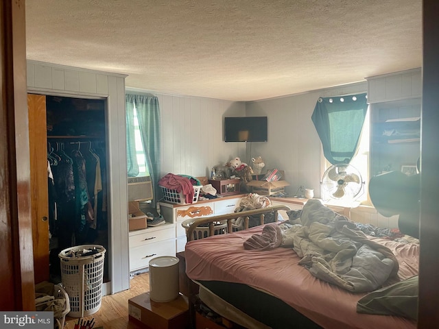 bedroom with a closet, light hardwood / wood-style floors, and a textured ceiling