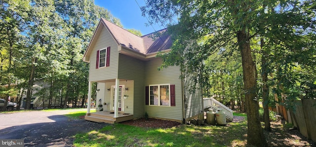 view of front of property with a front lawn, fence, and a shingled roof