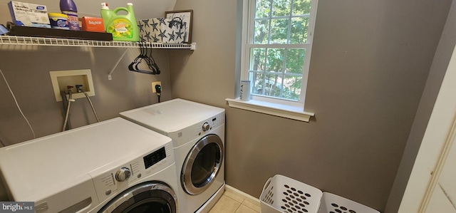 laundry room featuring washing machine and clothes dryer and light tile patterned flooring