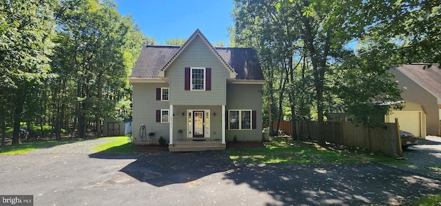 view of front of property with roof with shingles and fence