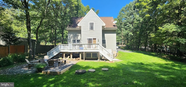 rear view of house featuring a deck and a lawn