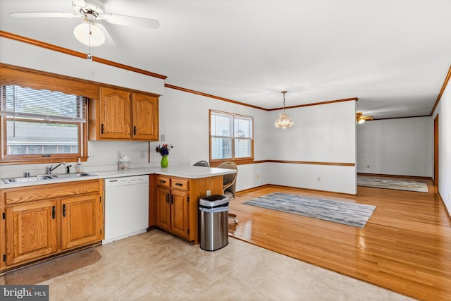 kitchen with ceiling fan with notable chandelier, kitchen peninsula, white dishwasher, decorative light fixtures, and plenty of natural light