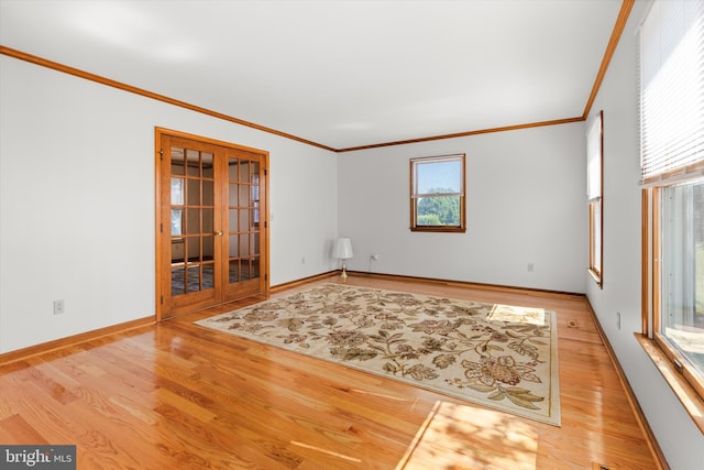 unfurnished room featuring french doors, crown molding, hardwood / wood-style floors, and a wealth of natural light