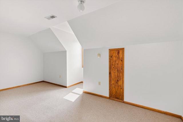 bonus room with carpet flooring and vaulted ceiling