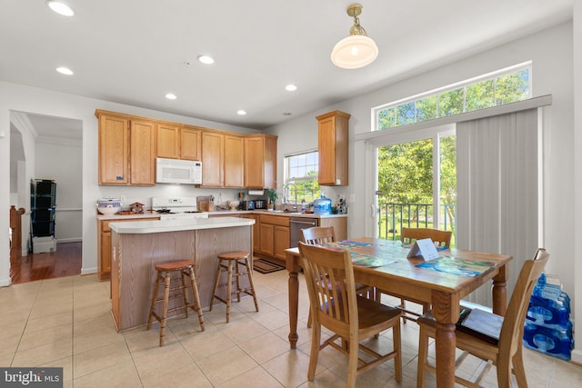 kitchen featuring ornamental molding, white appliances, light tile patterned floors, a center island, and sink