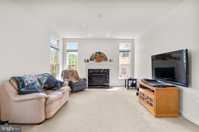 living room featuring light colored carpet and a high end fireplace