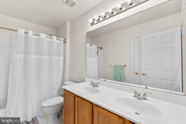 bathroom featuring walk in shower, toilet, and vanity