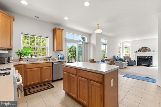 kitchen featuring light tile patterned floors, sink, a premium fireplace, a kitchen island, and stainless steel dishwasher