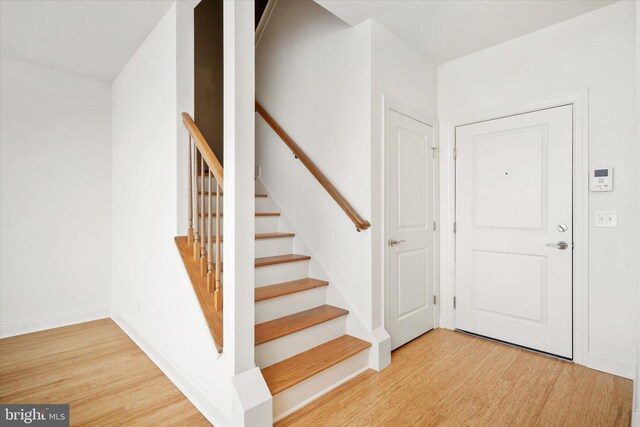 staircase featuring baseboards and wood finished floors