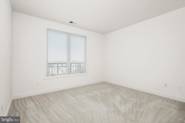 carpeted spare room featuring visible vents and baseboards