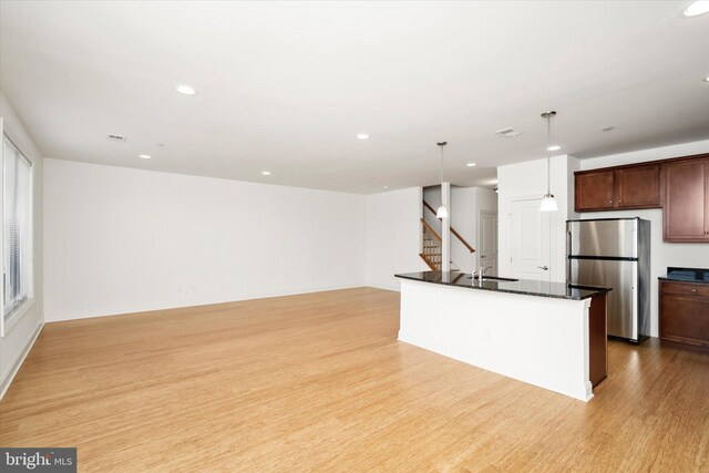 kitchen featuring visible vents, dark countertops, freestanding refrigerator, recessed lighting, and light wood-style floors