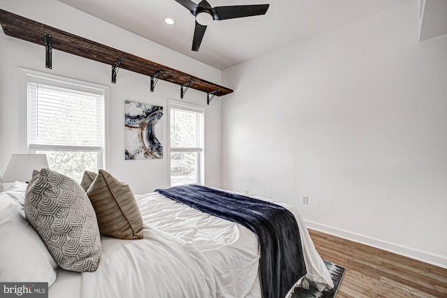 bedroom with multiple windows, ceiling fan, and hardwood / wood-style flooring