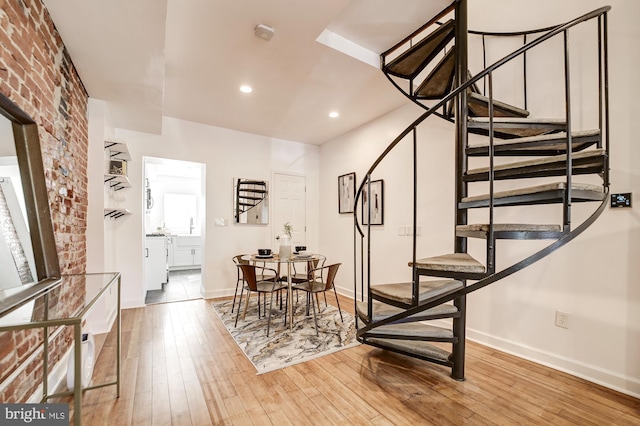 interior space featuring light wood-type flooring and brick wall