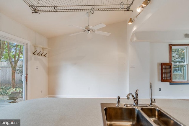 kitchen featuring carpet floors, sink, and ceiling fan