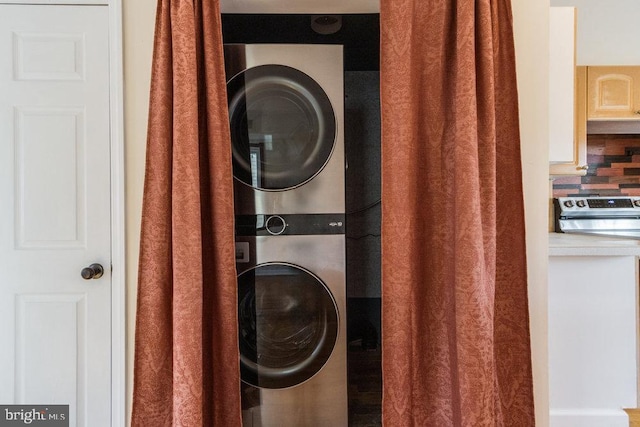 clothes washing area featuring stacked washer and dryer