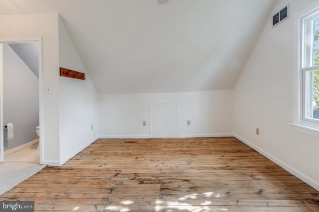 additional living space with vaulted ceiling, light hardwood / wood-style floors, and plenty of natural light