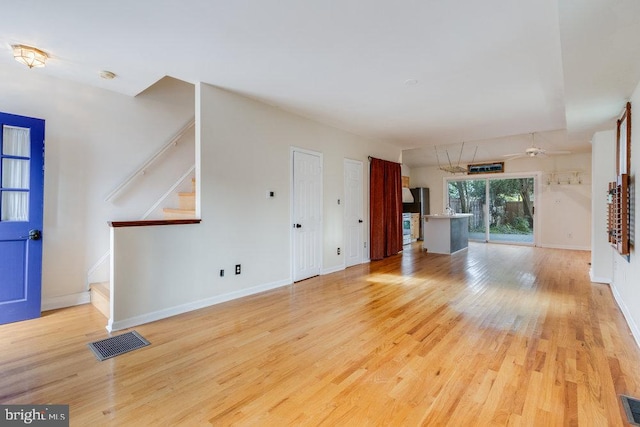 unfurnished living room with ceiling fan and light hardwood / wood-style flooring