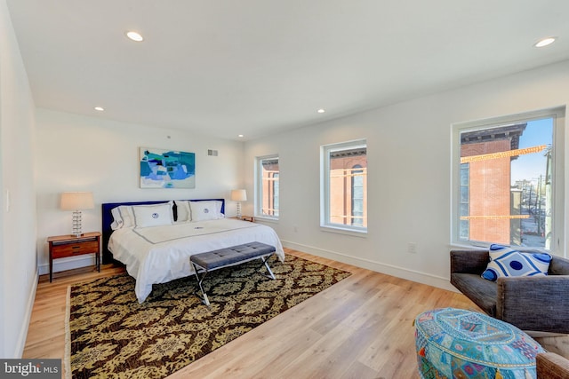 bedroom with light hardwood / wood-style flooring and multiple windows