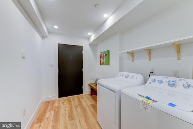 clothes washing area featuring washer and dryer and wood-type flooring