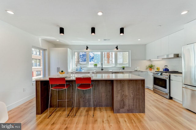 kitchen with plenty of natural light, a center island, stainless steel appliances, and white cabinets