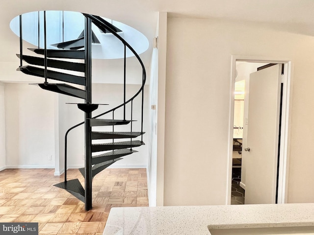 stairway featuring parquet floors