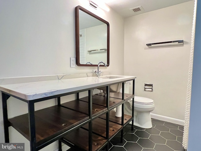 bathroom featuring vanity, toilet, and tile patterned floors