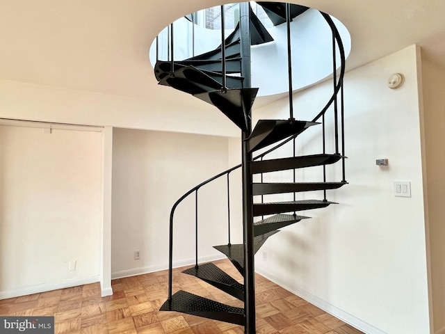 stairway featuring parquet floors