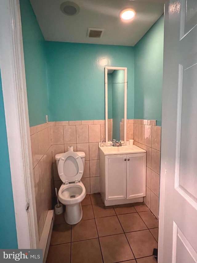 bathroom with tile patterned flooring, vanity, toilet, and tile walls