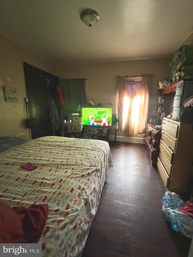 bedroom with dark hardwood / wood-style flooring