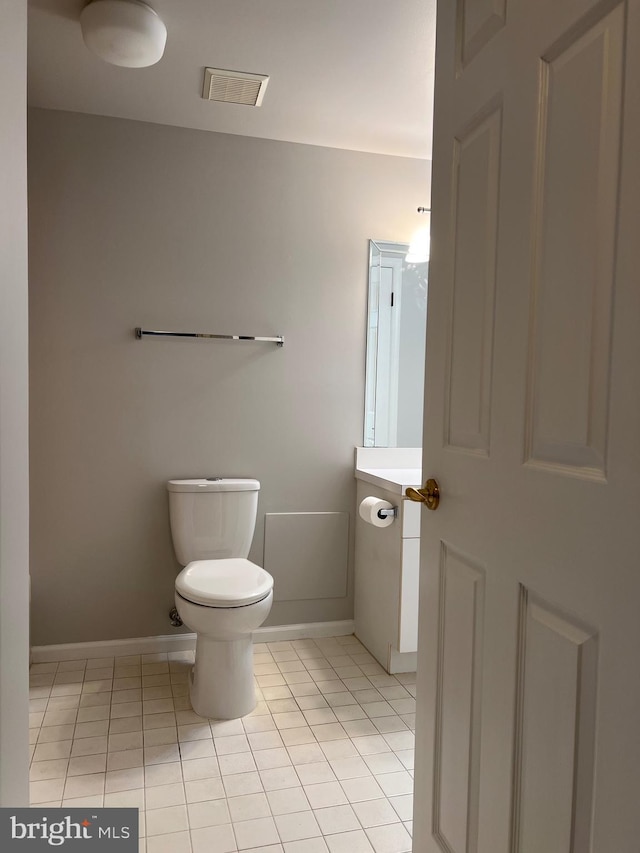 half bathroom featuring tile patterned floors, visible vents, toilet, baseboards, and vanity