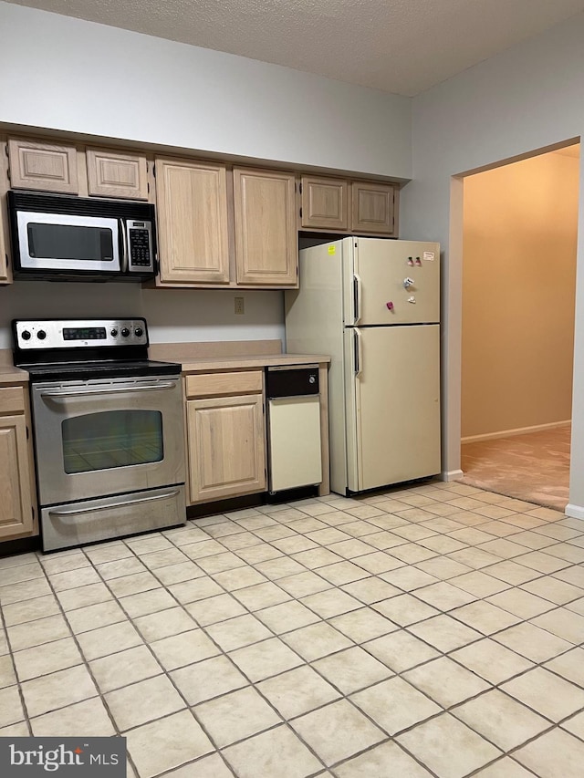 kitchen featuring light countertops, light brown cabinets, appliances with stainless steel finishes, and a textured ceiling