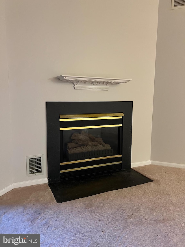 interior details featuring a fireplace with flush hearth, carpet, and visible vents