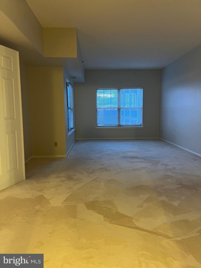 carpeted empty room featuring baseboards