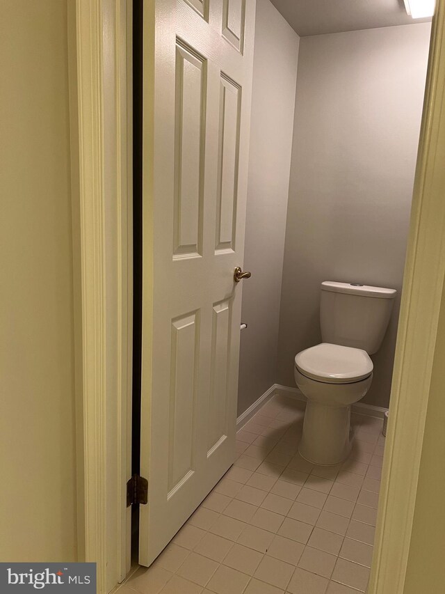 bathroom with tile patterned floors, baseboards, and toilet