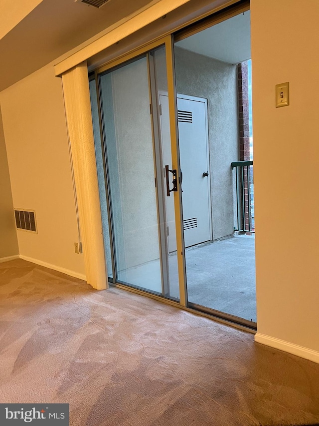 carpeted empty room featuring visible vents and baseboards