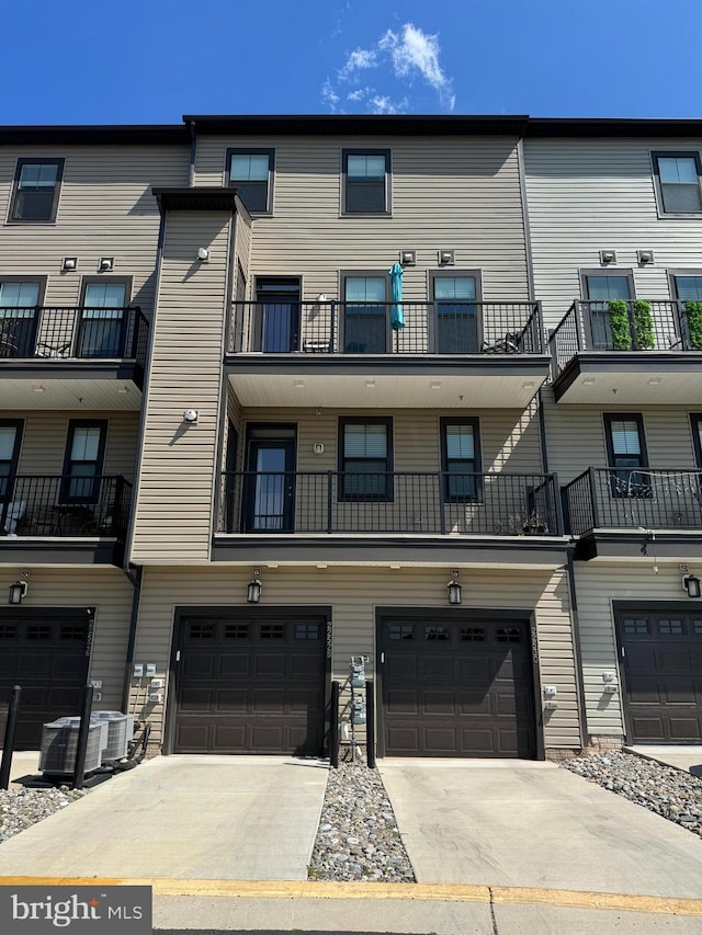 view of property featuring a garage and central air condition unit