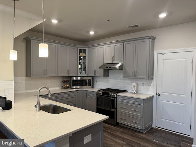 kitchen with pendant lighting, kitchen peninsula, stainless steel appliances, and gray cabinetry