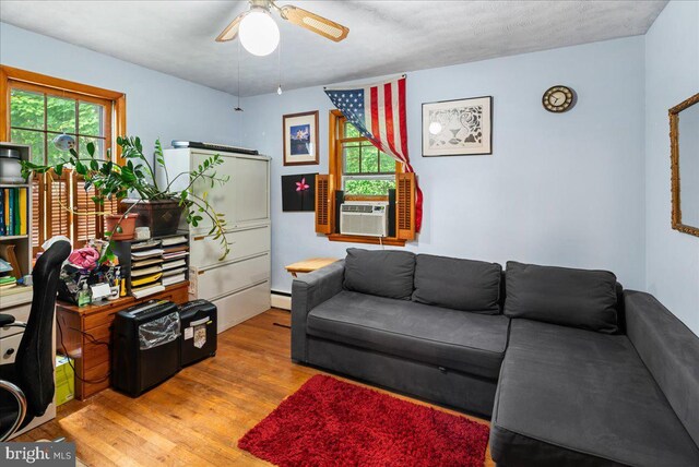 living room with a textured ceiling, cooling unit, ceiling fan, light hardwood / wood-style flooring, and a baseboard radiator