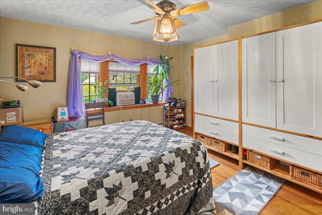 bedroom featuring a textured ceiling, ceiling fan, and light hardwood / wood-style flooring