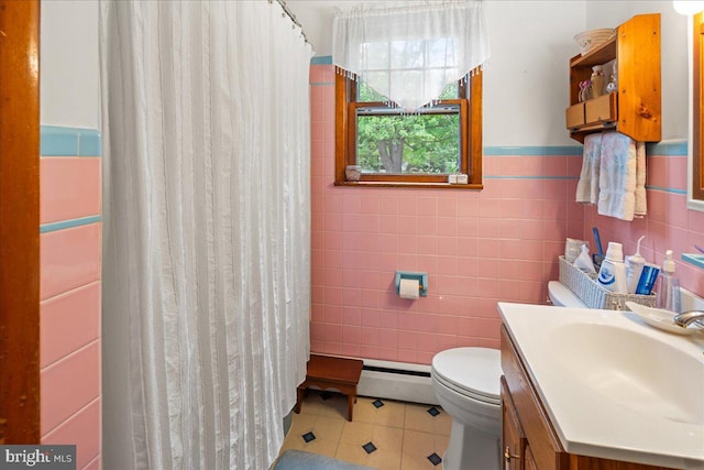 bathroom with vanity, baseboard heating, tile patterned floors, tile walls, and toilet