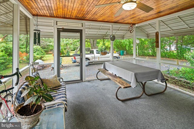 unfurnished sunroom featuring wood ceiling, vaulted ceiling, and ceiling fan